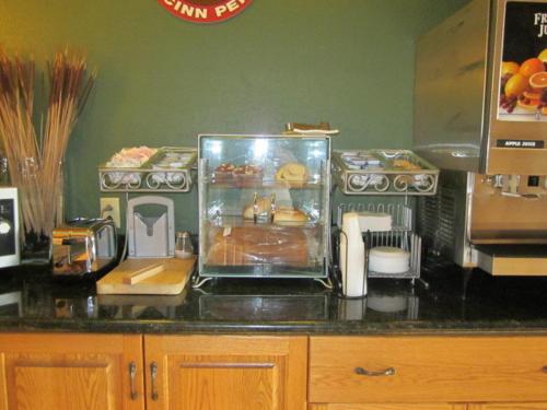 a kitchen with a counter top with food on it at AmericInn by Wyndham West Bend in West Bend