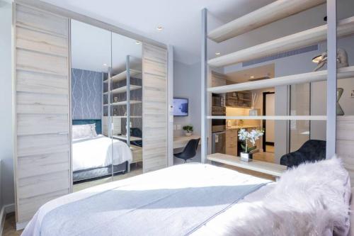 a bedroom with a bed and a large mirror at #AlimamaSpaces The Foreshore Haven in Cape Town