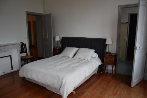 a bedroom with a bed with white sheets and pillows at LA MAISON DU DIRECTEUR DE SALIN DE GIRAUD in Salin-de-Giraud