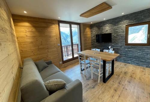 a living room with a couch and a table at Les Balcons de Valloire in Valloire