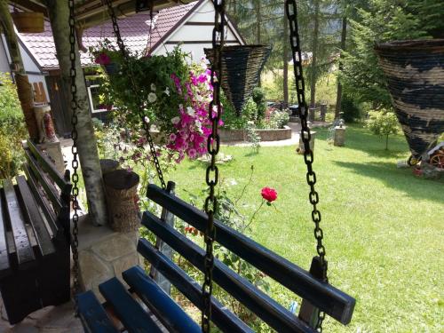 a swing in front of a yard with flowers at pensiunea Gabriela in Durau