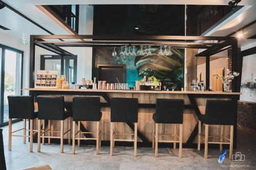 um bar num restaurante com cadeiras pretas em Ilkus Hotel & Restaurant em Krze