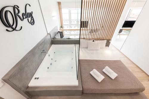 a bathroom with a bath tub with two white towels at Porto Sea View Apartments - Luxury Junior Suites in Thessaloniki