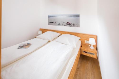 ノルダーナイにあるFerienwohnung Kleine Luiseのベッドルーム1室(ベッド2台付)が備わります。壁に絵が描かれています。