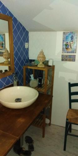 une salle de bain avec un lavabo et un miroir dans l'établissement LE COMPOSTELLE PRIEURE GITE LES MEDIEVALES, à Courchamps