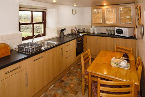 a kitchen with a wooden table and a wooden table and a tableablish at East Briscoe Farm Cottages in Barnard Castle