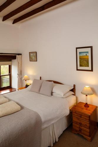 a bedroom with two beds and a table with lamps at East Briscoe Farm Cottages in Barnard Castle