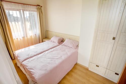 a small bedroom with a bed and a window at Mountain View Pirin Golf in Bansko