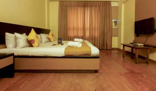 a bedroom with a large bed in a room at Celebrations Inn Pune in Pune
