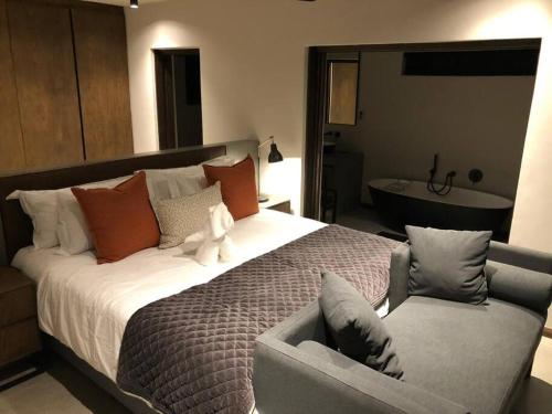 Un dormitorio con una cama grande con un osito de peluche. en Luxury Villa looking onto Kruger National Park, en Belfast