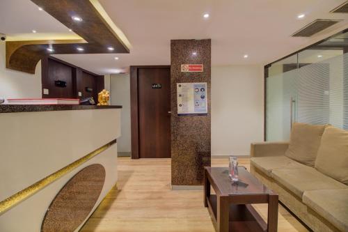孟买Hotel Malad Inn opposite Malad Railway Station的客厅配有沙发和桌子