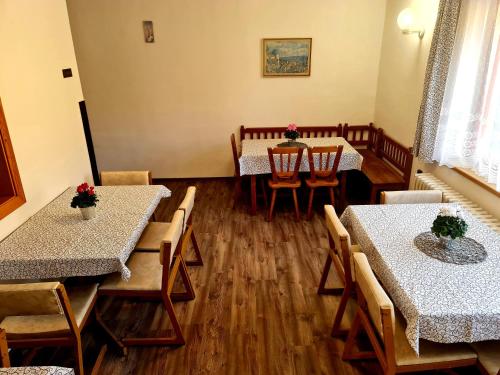 ein Esszimmer mit Tischen und Stühlen mit Blumen in der Unterkunft Penzion u vleku in Jablonec nad Jizerou