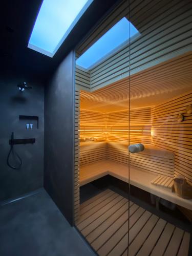 una sauna in un bagno con parete in vetro di B&B De Vrijboom a Kruisem
