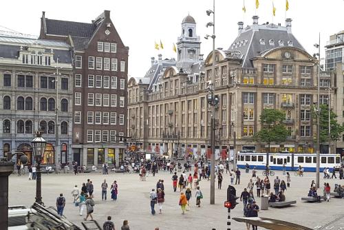 um grupo de pessoas andando em torno de uma praça da cidade em Hotel Ben Centre em Amsterdã