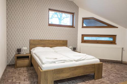 a bedroom with a bed and a window on the wall at Penzion U Jirsáka in Vikýřovice