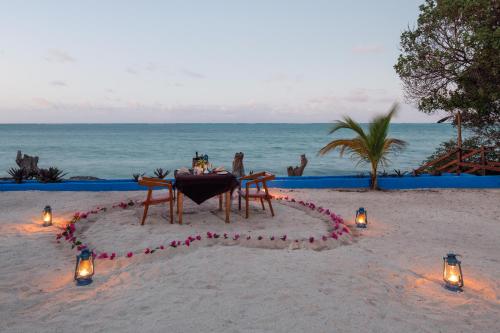 uma mesa na praia com luzes na areia em Moja Tuu The Luxury villas & Nature Retreat em Kiwengwa