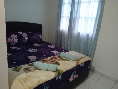 a bedroom with a bed with a purple comforter at Dongorit Cabin House no.2 in Kampong Kundassan