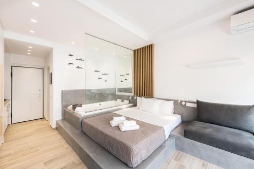 a bedroom with a large bed and a couch at Porto Sea View Apartments - Luxury Junior Suites in Thessaloniki