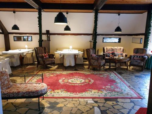 a room with tables and chairs and a red rug at Park Inn Resort in Mirosławiec