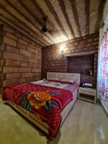 a bedroom with a bed in a brick wall at Gopal Home Stay & Guest House in Jodhpur