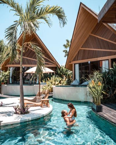 deux enfants jouant dans une piscine d'un complexe hôtelier dans l'établissement Beyond Bayou, à Seminyak