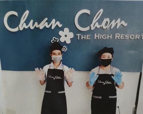 two chefs wearing aprons standing in front of a sign at Hotel Chuan Chom The High Resort Saraburi - SHA Plus in Sara Buri