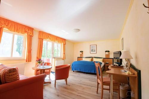 a bedroom with a bed and a table and chairs at Hotel Dünenschloss in Ostseebad Karlshagen