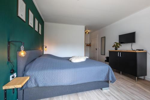 a bedroom with a blue bed and a flat screen tv at DOCK10TEXEL in De Cocksdorp