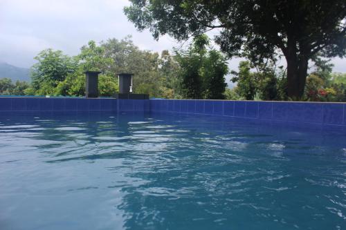 a swimming pool with a blue tile wall at Cogent Holiday Home in Gelioya