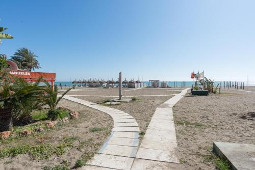 a path on the beach with the ocean in the background at La Nogalera Torremolinos Centro in Torremolinos