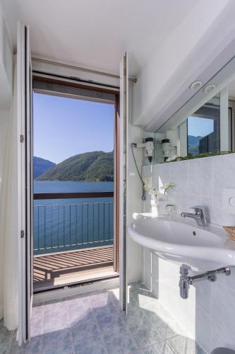 a bathroom with a sink and a large window at Hotel Riviera in Melide