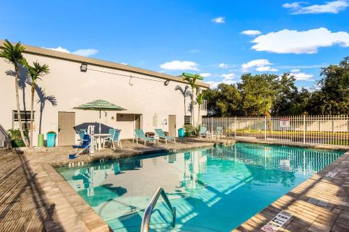 a swimming pool with a table and chairs next to a building at Quality Inn Bradenton - Sarasota North in Bradenton