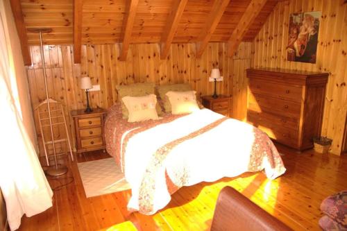 a bedroom with a bed in a wooden cabin at Apartamentos Tredos in Tredós