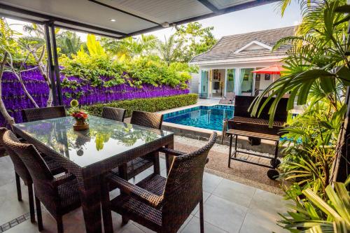 a patio with a table and chairs and a swimming pool at 3 Bedroom Exclusive Private Pool Villa Smooth as Silk in Ao Nang Beach