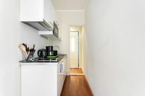 a kitchen with white cabinets and a wooden floor at Cadenabbia Lake side Apartments in Griante Cadenabbia