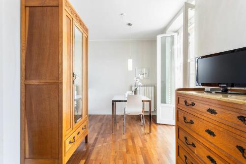 a room with a dresser with a television and a table at Cadenabbia Lake side Apartments in Griante Cadenabbia