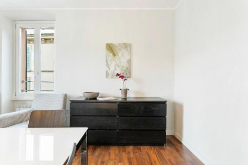 a black dresser in a white room with a table at Cadenabbia Lake side Apartments in Griante Cadenabbia