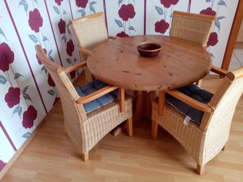 una mesa de madera con sillas y un bol de madera en la parte superior en Nordsee-Ferienanlage-Wohnung-Norderney, en Dornumersiel