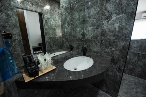 a bathroom with a sink and a mirror at Little Loft Hotel in Phuket Town