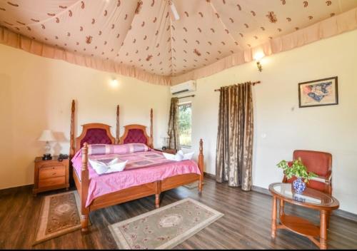 una camera da letto con un letto con lenzuola rosa e un tavolo di Lohana Village Resort a Pushkar