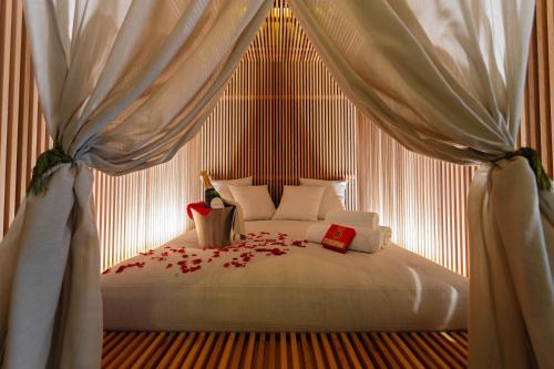 a bedroom with a bed with red flowers on it at Posia Retreat & Spa UNA Esperienze in San Foca