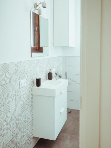 a white bathroom with a sink and a mirror at BRE Apartments - Fresche Frasche in Vicenza