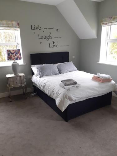 a bedroom with a large bed with words on the wall at Bedroom No 3 Garden view in Nobber