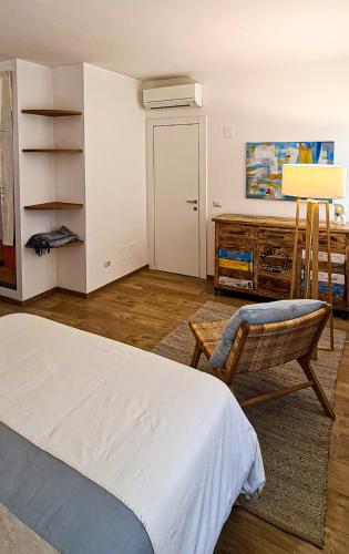 Un dormitorio con una cama, una silla y un escritorio. en La Cialdina, en Ancona