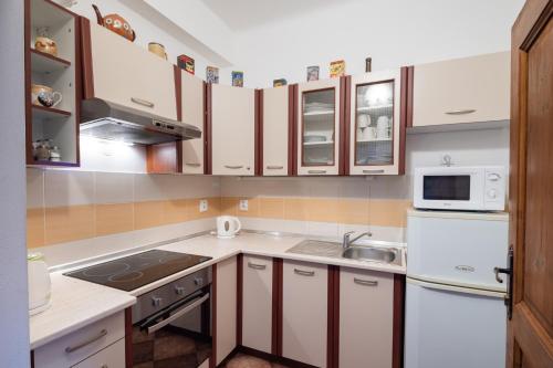 a kitchen with white cabinets and a sink at Penzion Tašner in Litomyšl