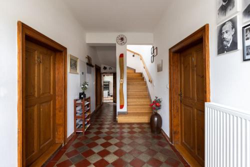 un couloir avec des portes en bois et une horloge sur le mur dans l'établissement Penzion Tašner, à Litomyšl