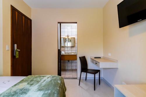 a bedroom with a bed and a desk and a chair at Hospedaria Santo André in Sao Paulo