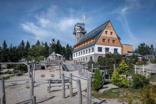 a large building with a clock tower on top of it at Hotel Královka in Bedřichov