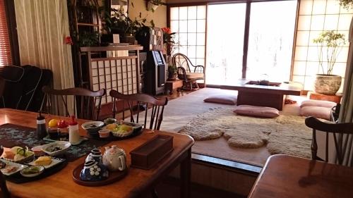 una sala de estar con una mesa con comida. en Lodge Amenouo, en Myoko