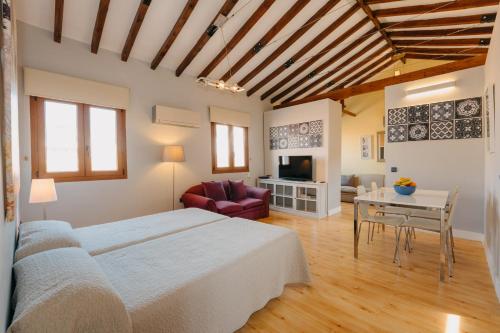 a room with a bed, table, chairs and a tv at Top2Stay Málaga in Málaga